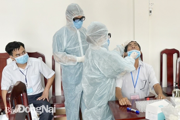 Cán bộ của Trung tâm kiểm soát bệnh tật tỉnh (thuộc Sở Y tế) tiến hành lấy mẫu xét nghiệm nhanh Covid-19 tại hội đồng thi Trường THPT Nguyễn Trãi (TP.Biên Hòa) (Ảnh: Công Nghĩa) 