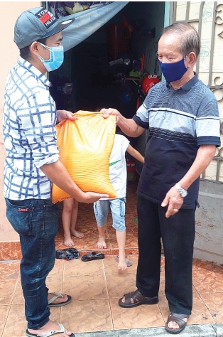Ông Mai Diền (phải), chủ nhà trọ tại P.Tam Hiệp, TP.Biên Hòa tặng quà cho công nhân lao động