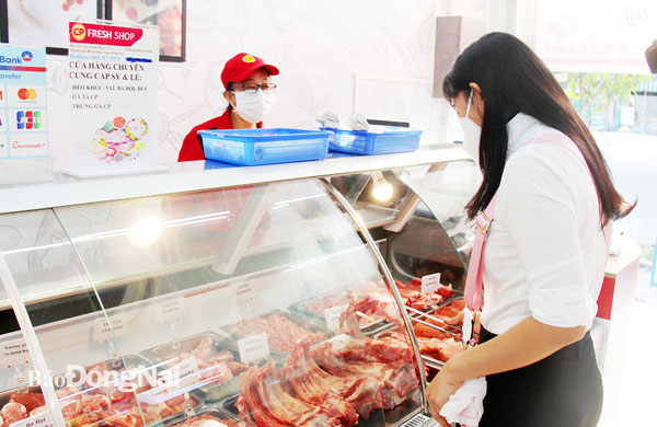 Khách hàng chọn mua các mặt hàng thịt heo tại một cửa hàng của Công ty CP Chăn nuôi C.P. ở TP.Biên Hòa. Ảnh: H.Hải