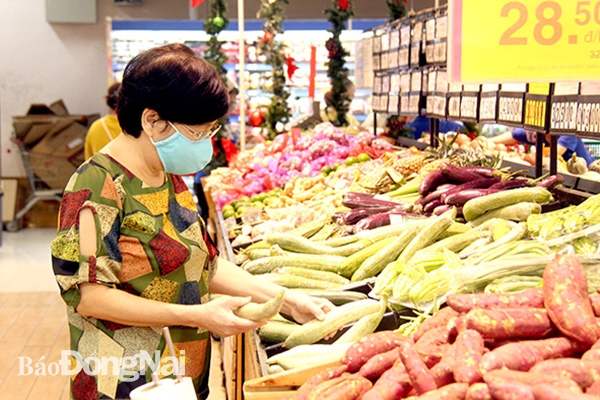 Nhiều siêu thị triển khai các chương trình kích cầu tiêu dùng dành cho các mặt hàng nông sản Việt vào dịp cuối năm 2021 và đầu năm mới 2022. Trong ảnh: Người tiêu dùng chọn mua các mặt hàng nông sản Việt tại một siêu thị ở TP.Biên Hòa