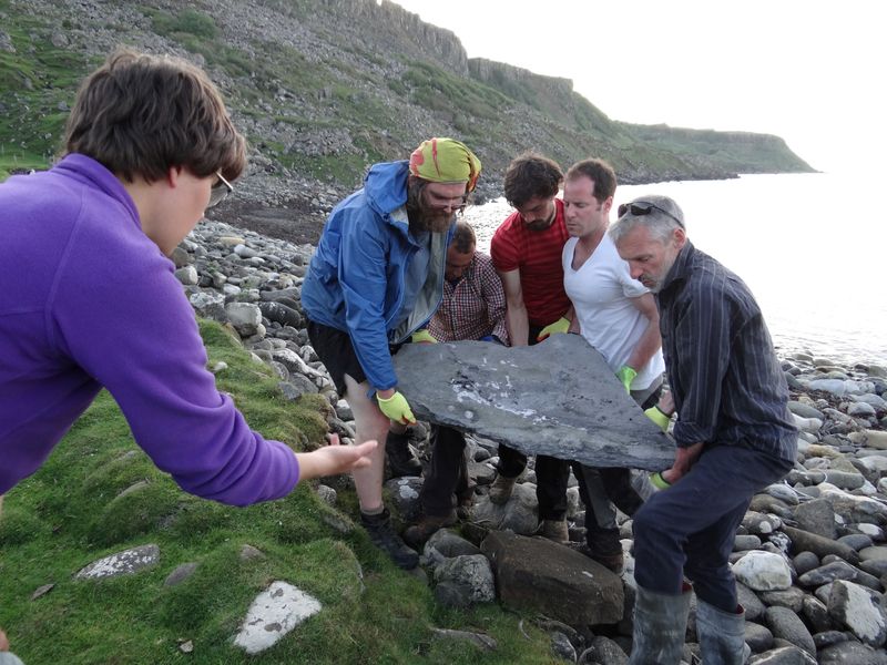 Researchers carry part of the fossil of a newly identified Jurassic Period flying reptile, at Scotland's Isle of Skye