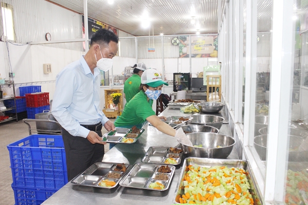 Ông Trịnh Thanh Nghị kiểm tra suất ăn trước khi giao cho doanh nghiệp. Ảnh: V.Thế