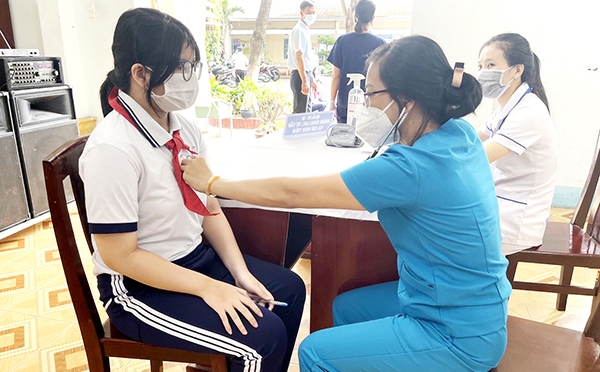 Nhân viên y tế khám sàng lọc trước tiêm vaccine ngừa Covid-19 cho một học sinh lớp 6 Trường THCS Nguyễn Bỉnh Khiêm (TP.Biên Hòa) vào ngày 19-4. Ảnh: Kim Liễu