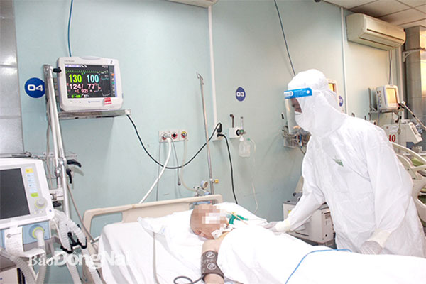BS CKI Đồng Minh Hùng, Trưởng khoa Nhiễm Bệnh viện Đa khoa Đồng Nai kiểm tra sức khỏe bệnh nhân Covid-19 nặng tại Khu Hồi sức Covid-19. Ảnh: Hạnh Dung