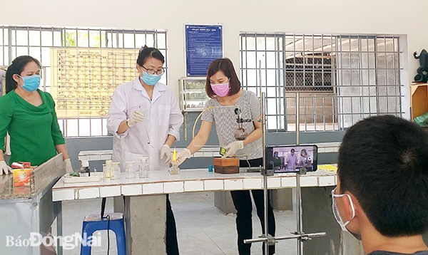 Giáo viên Trường THCS Trần Hưng Đạo (TP.Biên Hòa) ghi lại bài thí nghiệm hóa học bằng điện thoại di động