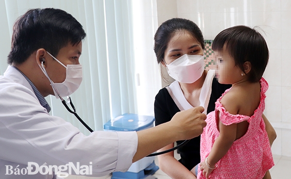 Bác sĩ của Bệnh viện đa khoa Đồng Nai khám sàng lọc cho trẻ trước khi tiêm vaccine