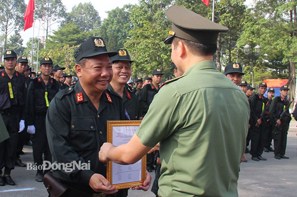 Thiếu thướng Vũ Hồng Văn, Giám đốc Công an tỉnh trao quyết định thành lập Trung đoàn Cảnh sát cơ động dự bị chiến đấu và tặng hoa cho Ban chỉ huy. Ảnh: Trần Danh