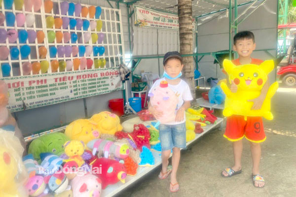Các bé trúng thưởng sau khi tham gia trò chơi ném phi tiêu tại Khu du lịch Đảo Ó - Đồng Trường