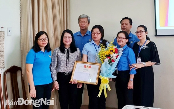Đại diện Liên đoàn Lao động tỉnh, Công đoàn Khu công nghiệp Biên Hòa và Công đoàn cơ sở công ty chụp hình cùng bà Lê Thị Vân tại buổi lễ khen thưởng.