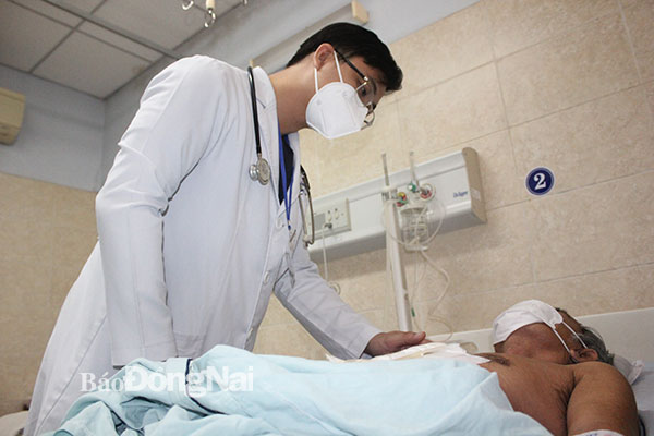 Bác sĩ kiểm tra sức khỏe cho bệnh nhân sáng 12-8. Ảnh: Hạnh Dung
