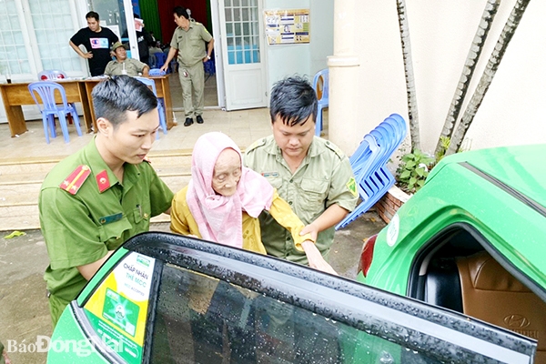 Lực lượng công an hỗ trợ đón người cao tuổi, đi lại khó khăn đến trụ sở Công an P.Tam Phước (TP.Biên Hòa) làm căn cước công dân. Ảnh: CTV