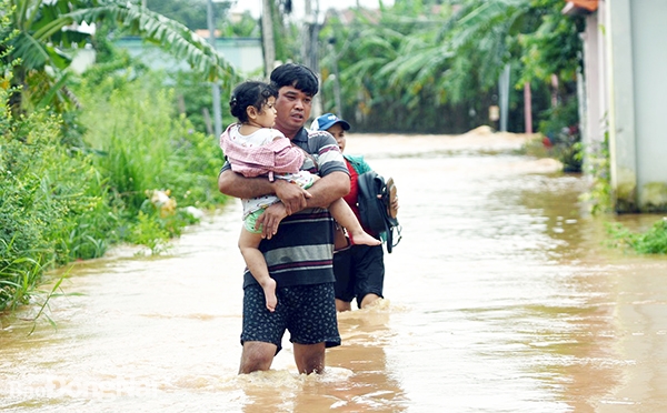 Người dân di chuyển khó khăn trong nước ngập tại Phường Phước Tân, TP Biên Hòa ngập sâu do nước từ thượng nguồn sông Buông đổ về