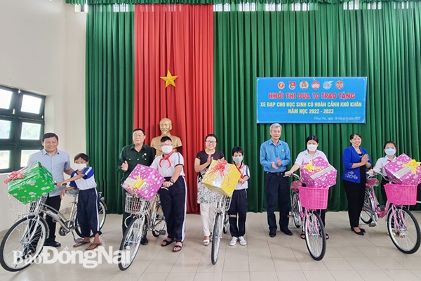 Các thành viên Khối thi đua số 10 trao quà cho các em học  sinh khó khăn tại xã Hiếu Liêm, H.Vĩnh Cửu
