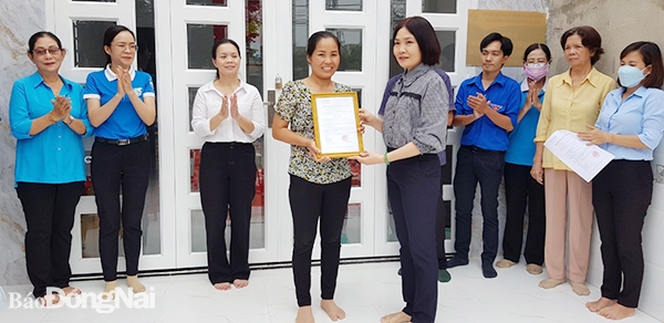 Phó chủ tịch UBND phường Xuân Bình Nguyễn Thị Thanh trao quyết định tặng Mái ấm tình thương cho gia đình chị Dân