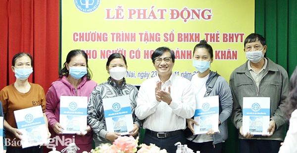 Phó chủ tịch UBND tỉnh Nguyễn Sơn Hùng trao tặng sổ BHXH cho người dân (ảnh: Mai Minh)