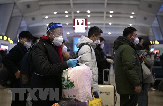 Hành khách xếp hàng chờ lên tàu tại nhà ga ở Bắc Kinh, Trung Quốc. (Ảnh: AFP/TTXVN)