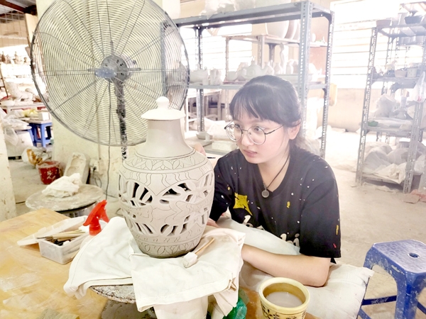 Sinh viên Trường cao đẳng Mỹ thuật trang trí Đồng Nai thực hiện công đoạn trang trí sản phẩm gốm