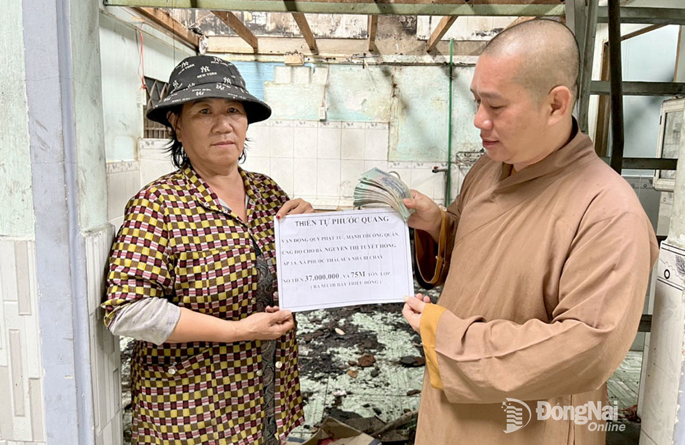 Đại đức Thích Nguyên Thông, Phó ban Trị sự Giáo hội Phật giáo H.Long Thành, Trụ trì thiền tự Phước Quang (xã Phước Thái, H.Long Thành) trao hỗ trợ kinh phí sửa chữa nhà cho một hộ dân trên địa bàn H.Long Thành. Ảnh: H.Thảo