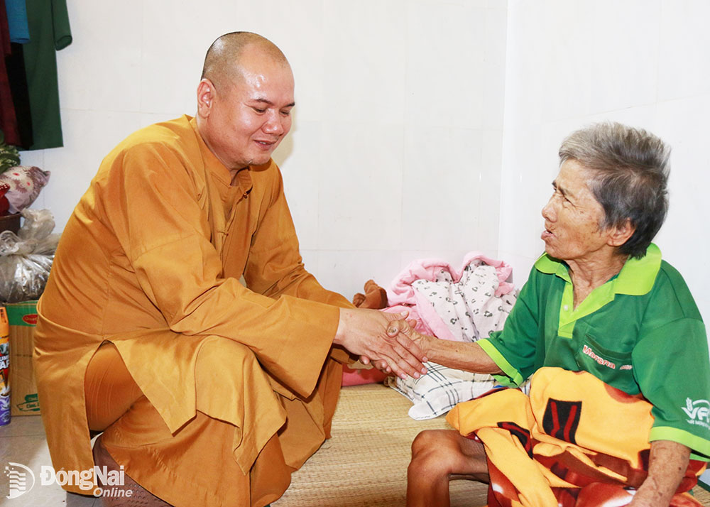 Thượng tọa Thích Giác Đăng, Phó trưởng ban Trị sự Giáo hội Phật giáo Việt Nam TP.Long Khánh bên cụ già đang được ông chăm sóc