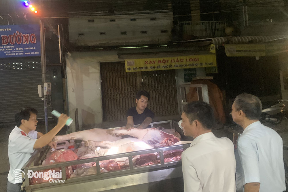 Lực lượng chức năng kiểm tra xe chở thịt heo vào chợ Tam Hòa (TP.Biên Hòa). Ảnh: B.Nguyên