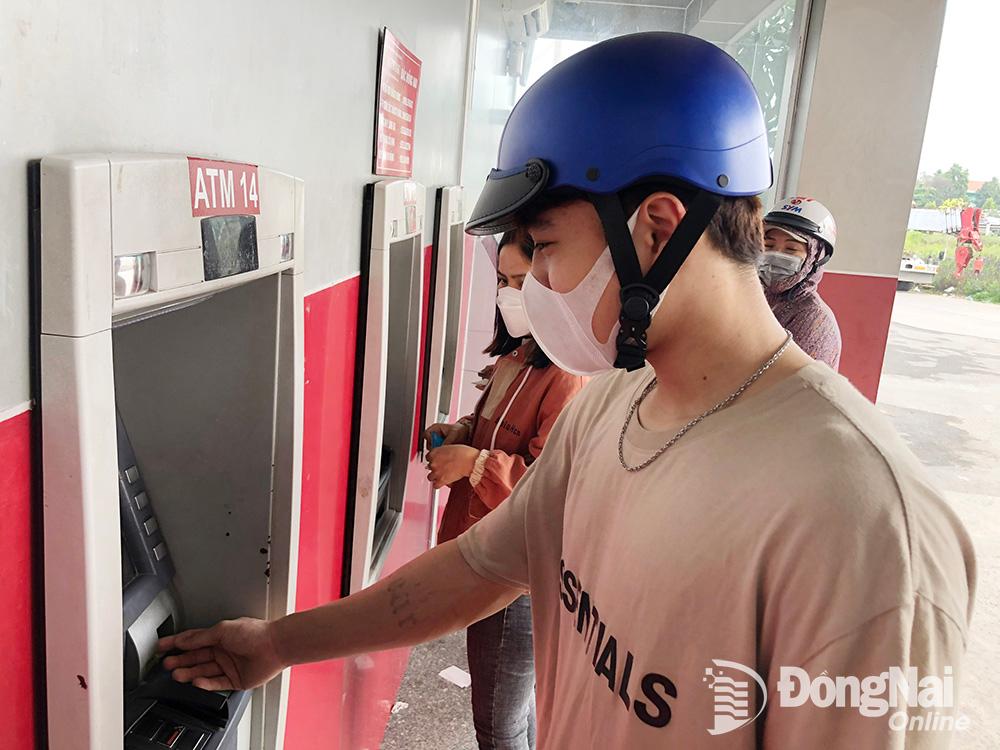 Người dân giao dịch thông qua hệ thống ATM tại một chi nhánh ngân hàng ở TP.Biên Hòa. (Ảnh: Hải Quân)