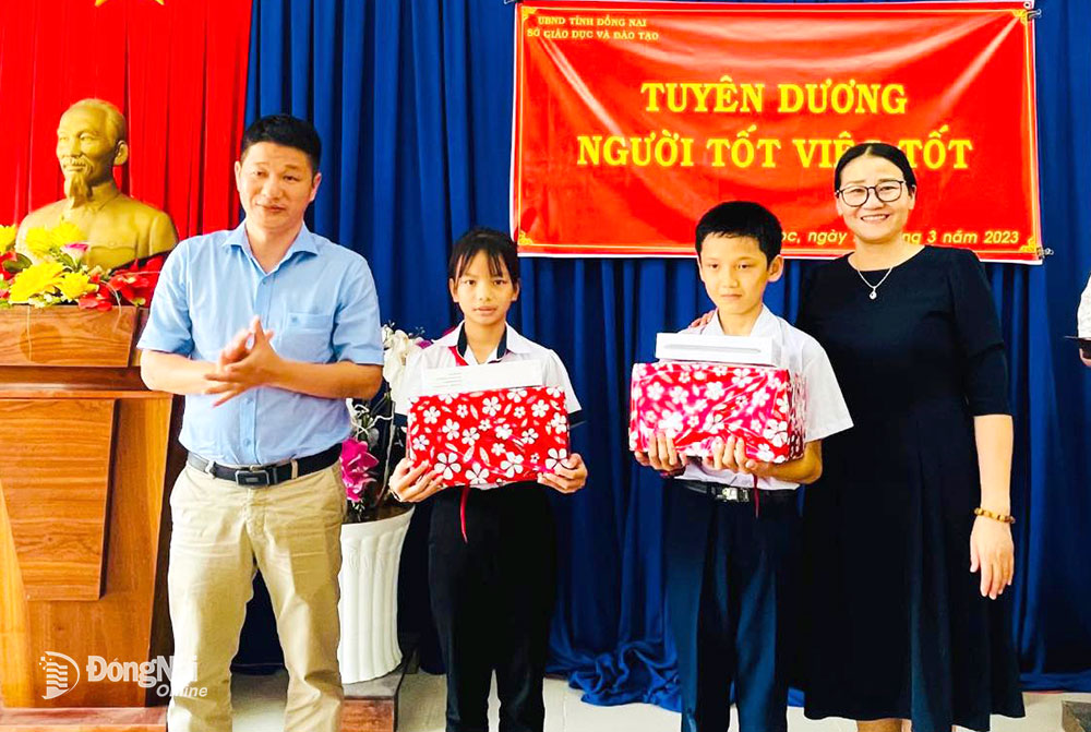 Phó giám đốc Sở GD-ĐT Đỗ Đăng Bảo Linh trao khen thưởng cho 2 em Lê Nhã Trâm và Nguyễn Quốc Kỳ
về hành động đẹp nhặt được của rơi trả người đánh mất. Ảnh: H.Thảo
