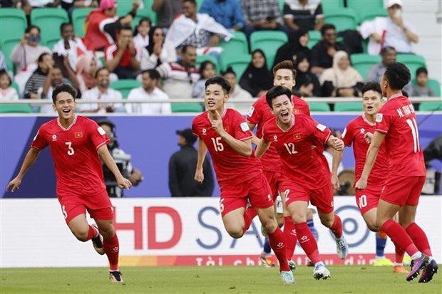 Nguyen Dinh Bac (No 15) and other players of Vietnam celebrate the leveling goal in the first half of the game against Japan. (Photo: AFP/VNA) 
