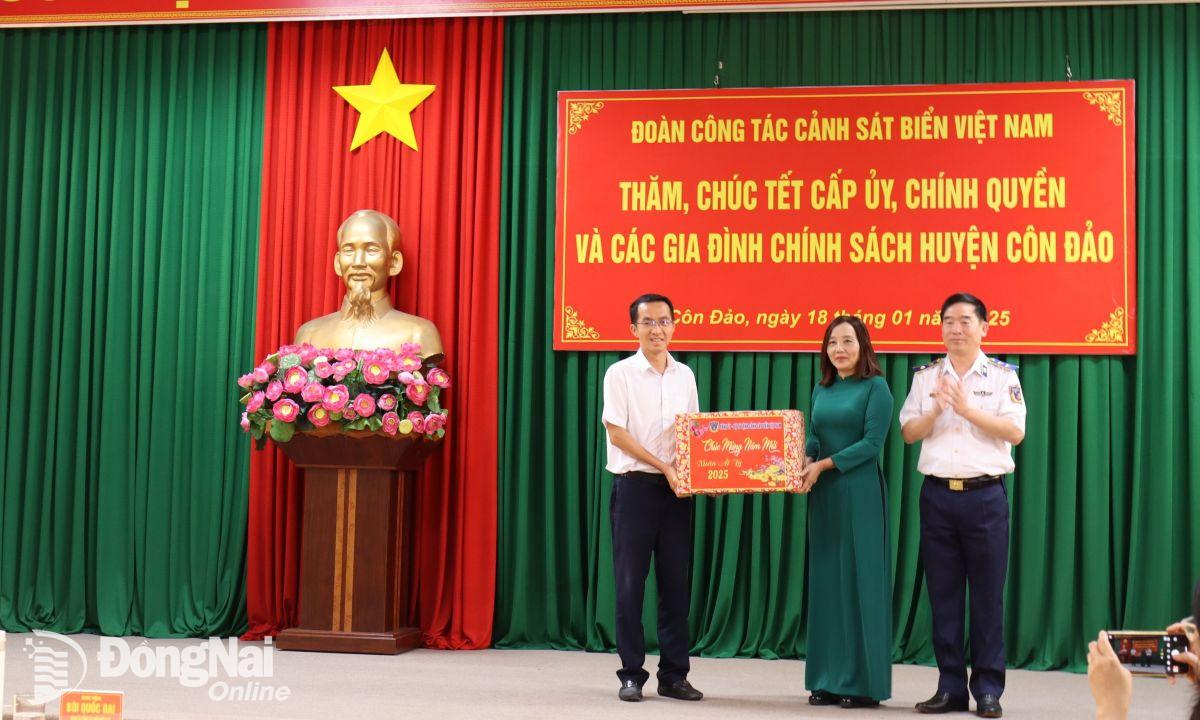 Trung tướng Bùi Quốc Oai (bìa phải) tặng quà chúc Tết huyện Côn Đảo. Ảnh: Nguyệt Hà