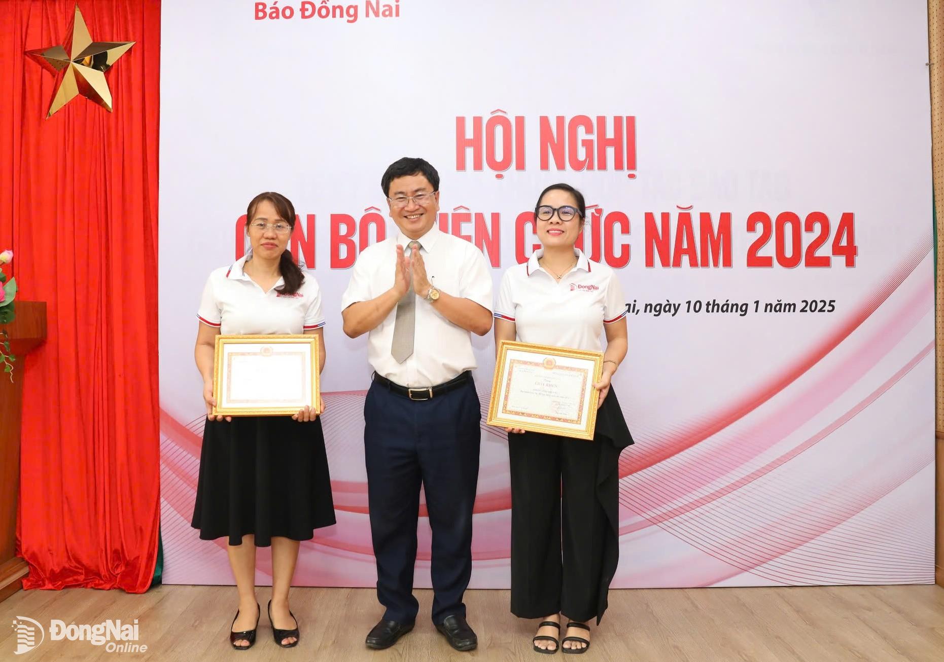 Tổng Biên tập Báo Đồng Nai Đào Văn Tuấn tặng giấy khen cho 2 tập thể lao động xuất sắc. Ảnh: Huy Anh