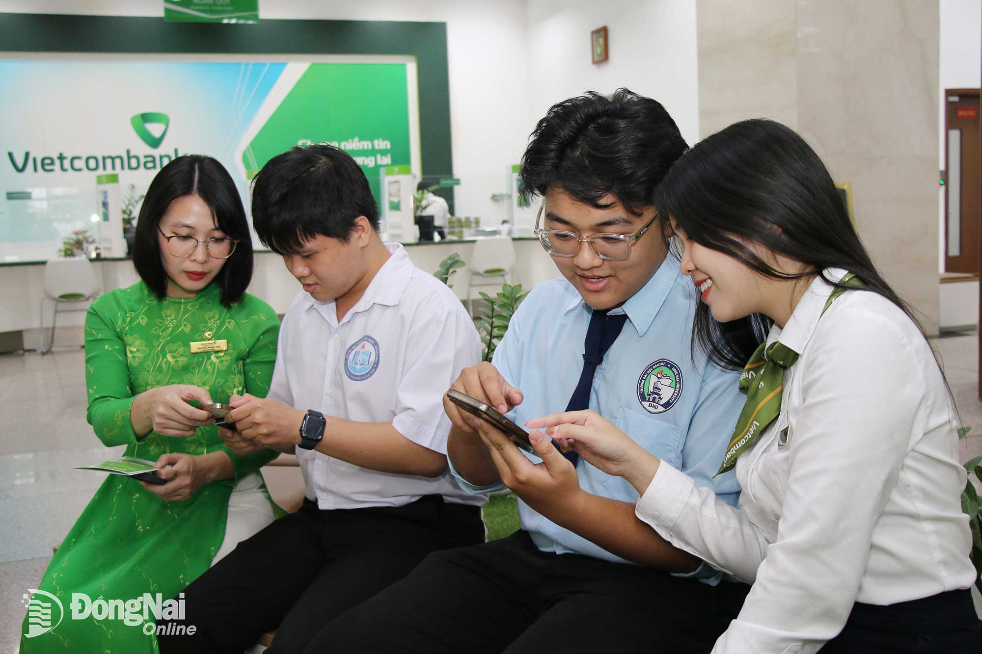 Nhân viên Vietcombank chi nhánh Đồng Nai (ở phường Trấn Biên) hỗ trợ sinh viên Trường đại học Đồng Nai sử dụng các tiện ích ngân hàng số, thanh toán trực tuyến thông qua ứng dụng của Vietcombank. Ảnh: Hải Quân