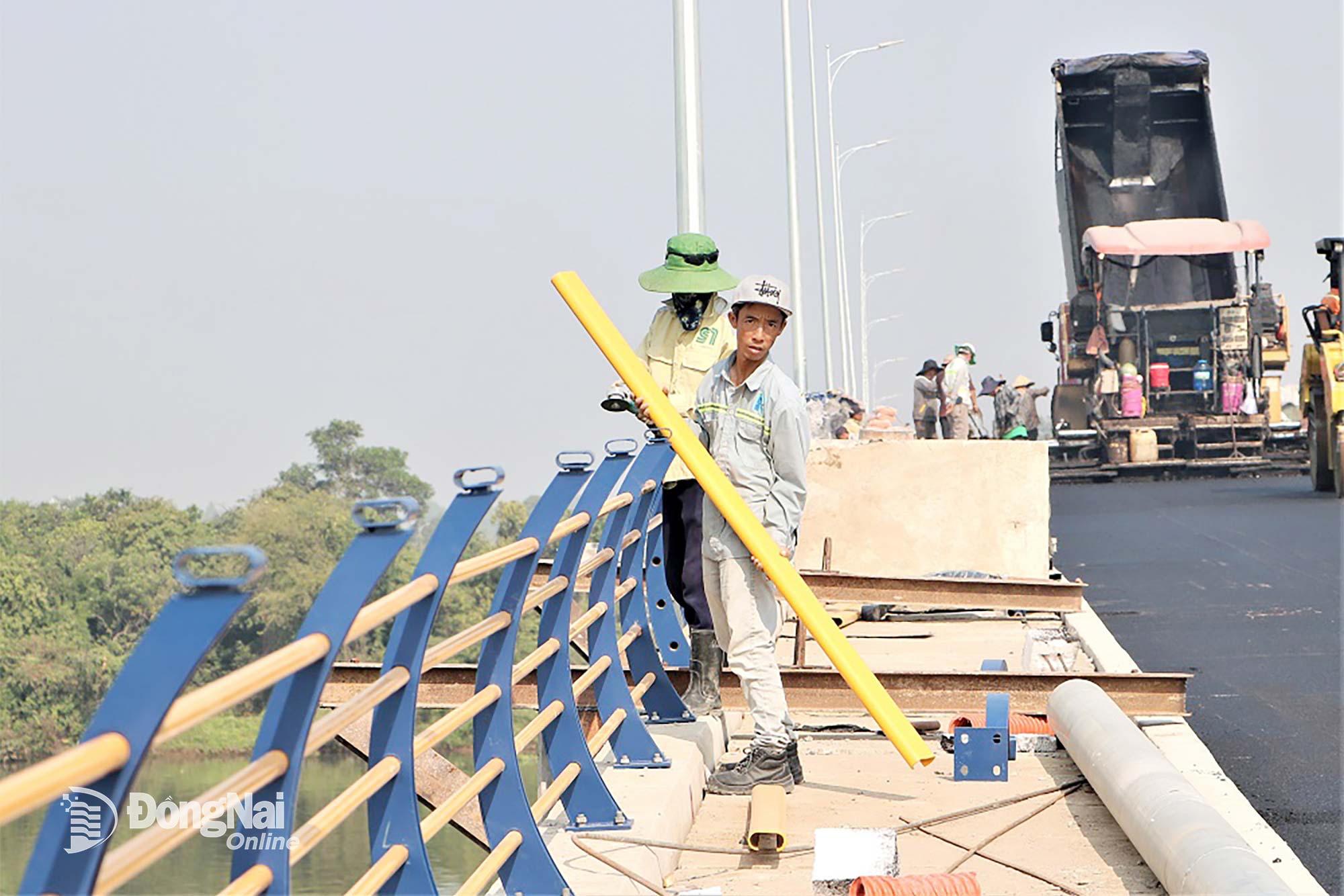Along with asphalt paving on the bridge deck, finishing works on Thong Nhat Bridge, such as installing guardrail systems, are also underway. Photo: Pham Tung