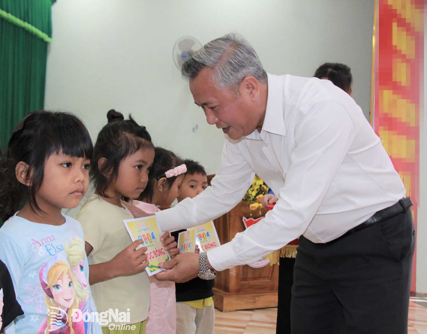 Phung Hiep Quoc, Member of the Provincial Party Committee, Secretary of the Dak O Commune Party Committee, and Chairman of the Commune People’s Council, presents scholarships to students. Photo: Nga Son