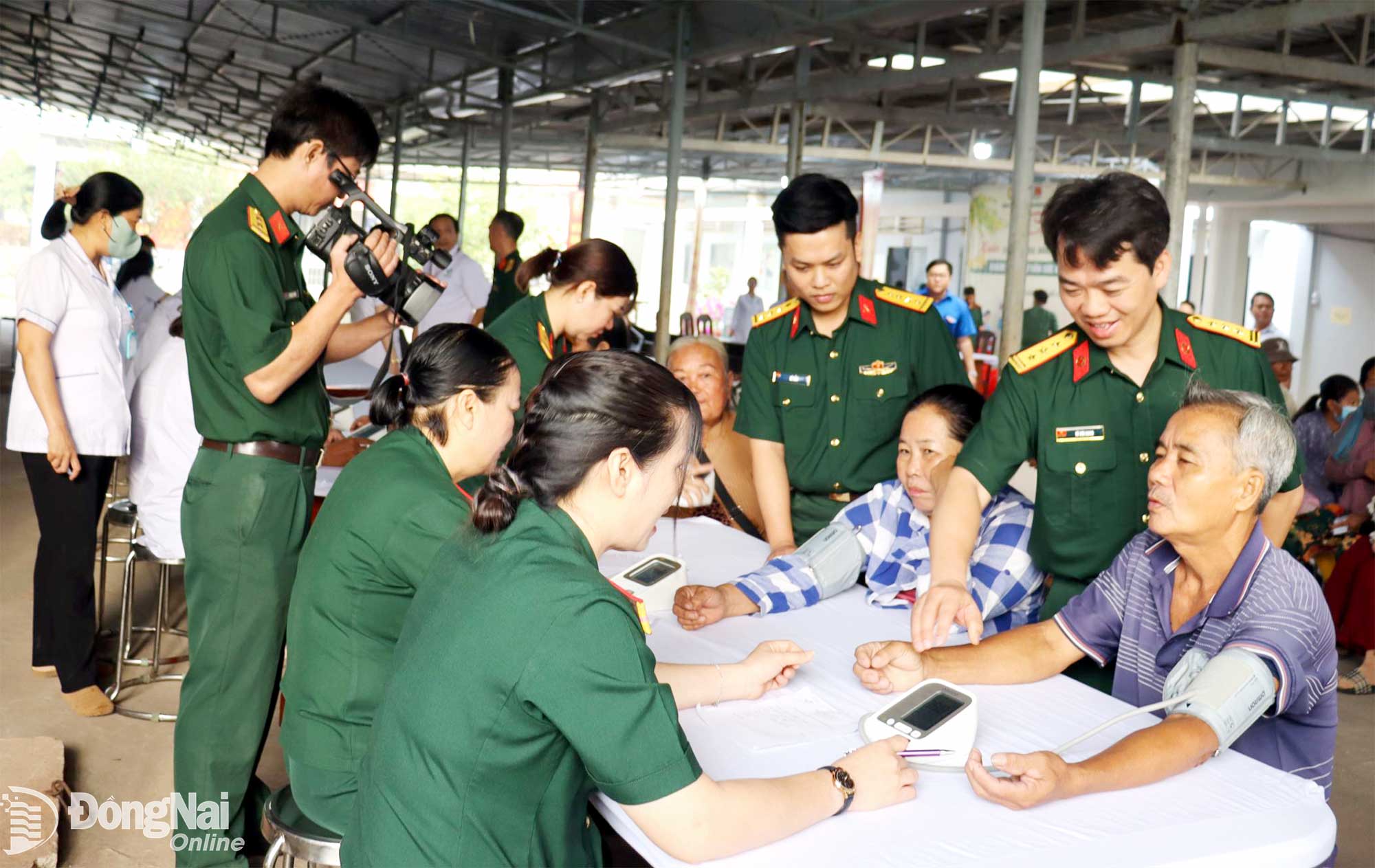 Đại biểu Bệnh viện Quân y 175 và Ban Thanh niên quân đội thăm hỏi, động viên người dân đến khám bệnh, tư vấn sức khỏe. Ảnh: Nguyệt Hà