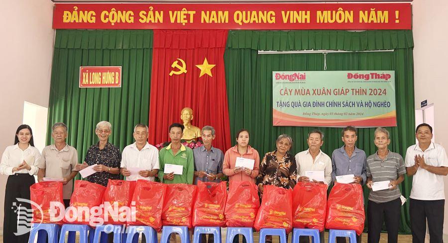 Phó tổng biên tập Báo Đồng Nai Hoàng Thị Bích Phú (ngoài cùng bìa trái) và lãnh đạo địa phương tặng quà cho người dân xã Long Hưng B