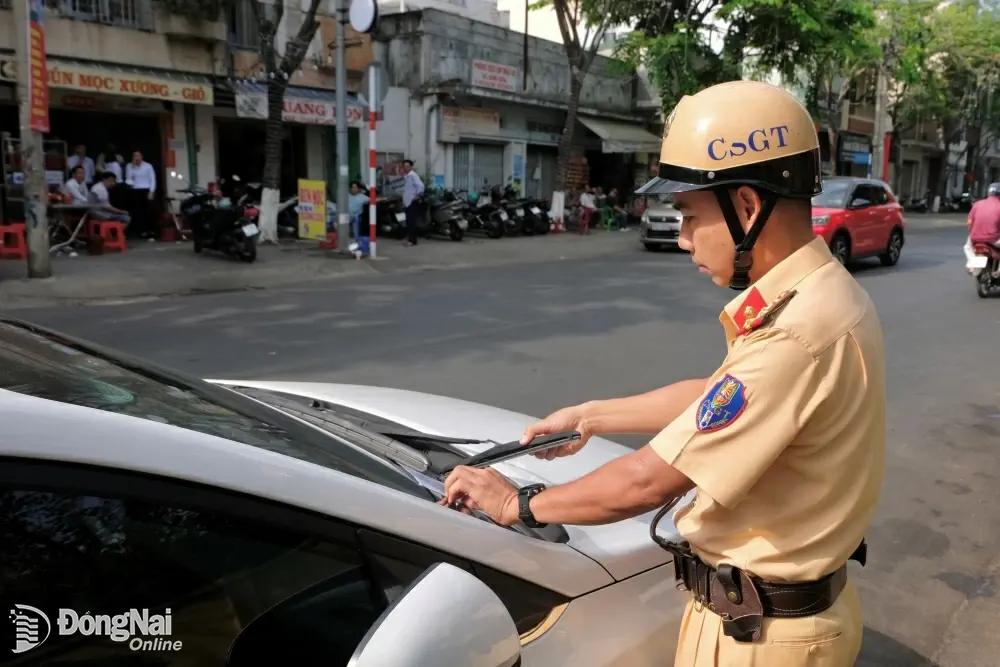 Lực lượng cảnh sát giao thông - trật tự sẽ kẹp thông báo vào kính chắn gió trước xe. Ảnh: Đăng Tùng
