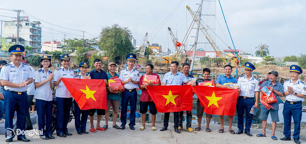 Đại tá Lê Văn Tú, Bí thư Đảng ủy, Chính ủy Vùng Cảnh sát biển 3 (giữa) tặng quà, trao cờ Tổ quốc cho ngư dân dịp Tết Nguyên đán 2024