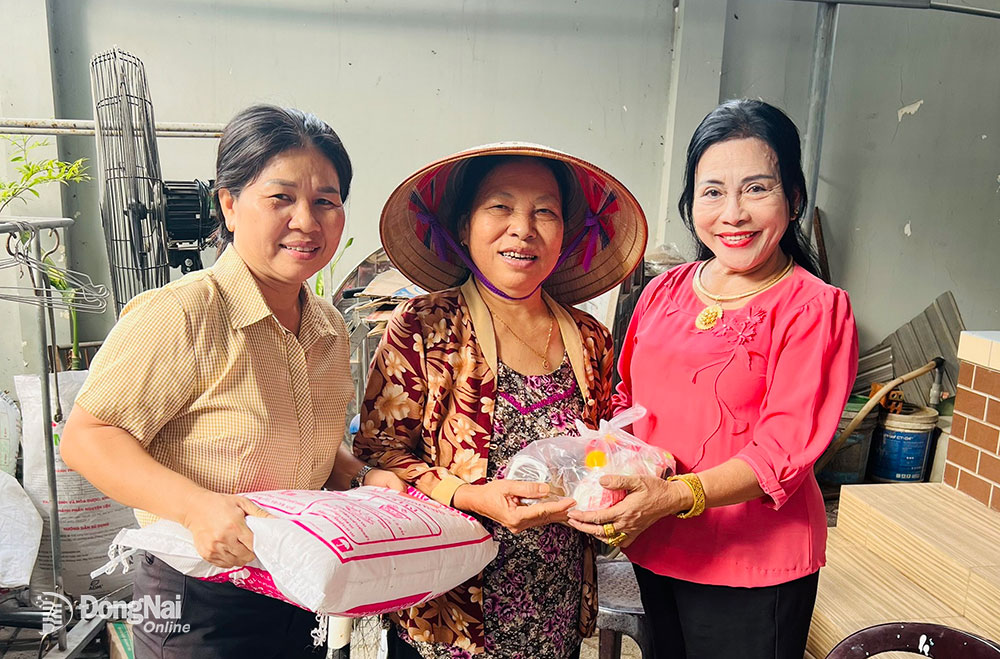 Bà Bùi Thị Đào (bìa phải) và Chủ tịch Hội LHPN TT.Long Thành Đỗ Thị Thúy Lan cùng trao quà cho hội viên phụ nữ có hoàn cảnh khó khăn
