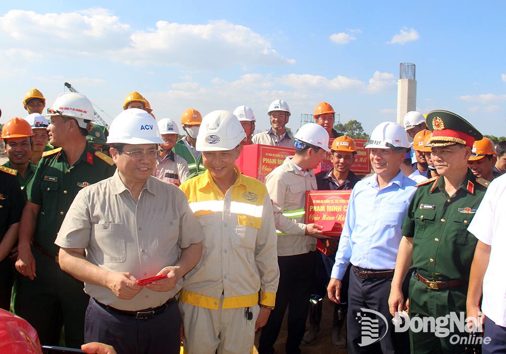 Thủ tướng Chính phủ Phạm Minh Chính chúc tết, động viên, lì xì đầu năm cho công nhân, người lao động tại công trường thi công dự án đường cao tốc Biên Hòa – Vũng Tàu. (Ảnh: Hải Quân)