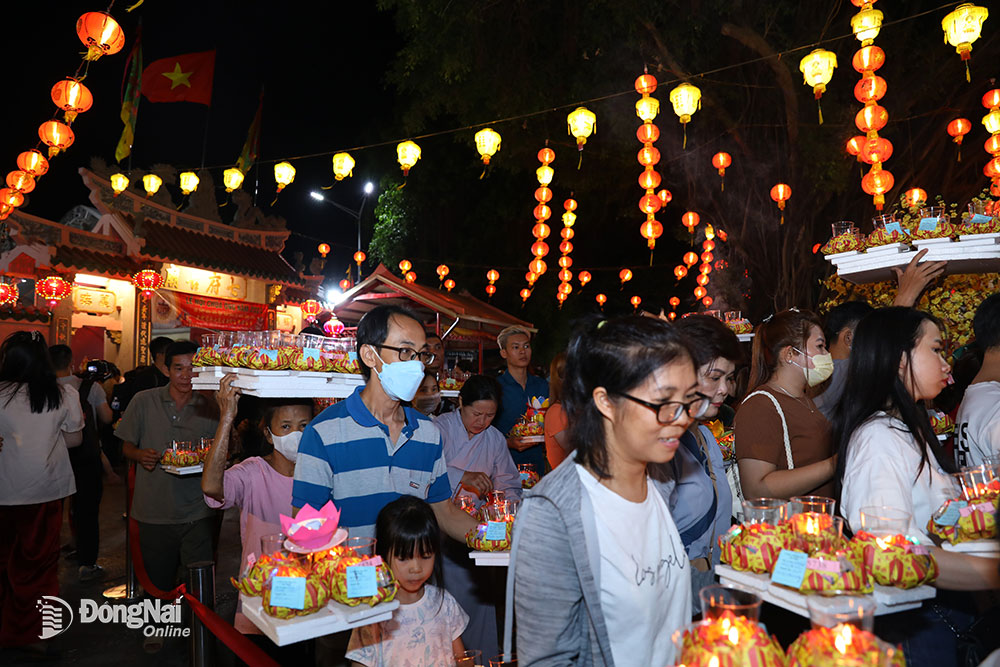 Sau khi thả đèn hoa đăng ở trên sông Đồng Nai, các du khách, người dân xếp hàng chờ tới lượt được thả hoa đăng ở bờ sông Đồng Nai