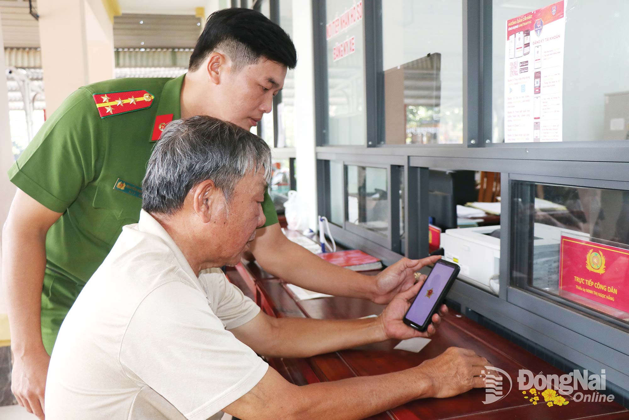Binh Long Ward police officers assist residents in installing the VNeTraffic transport application. Photo: Cam Lien