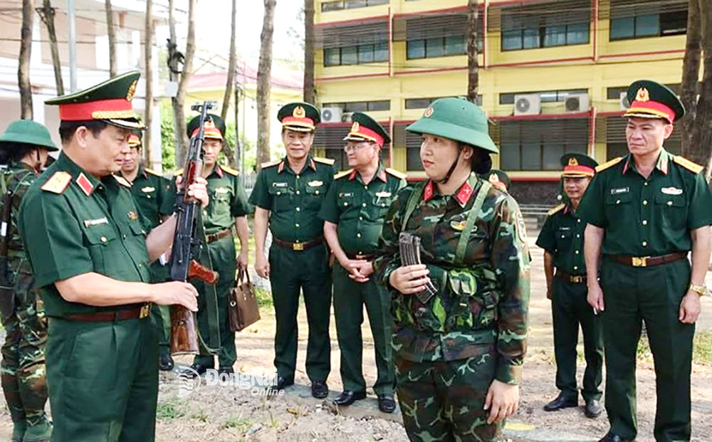 Trung tướng Trần Hoài Trung hướng dẫn nữ tân binh bài 1 súng AK. Ảnh: N.Anh