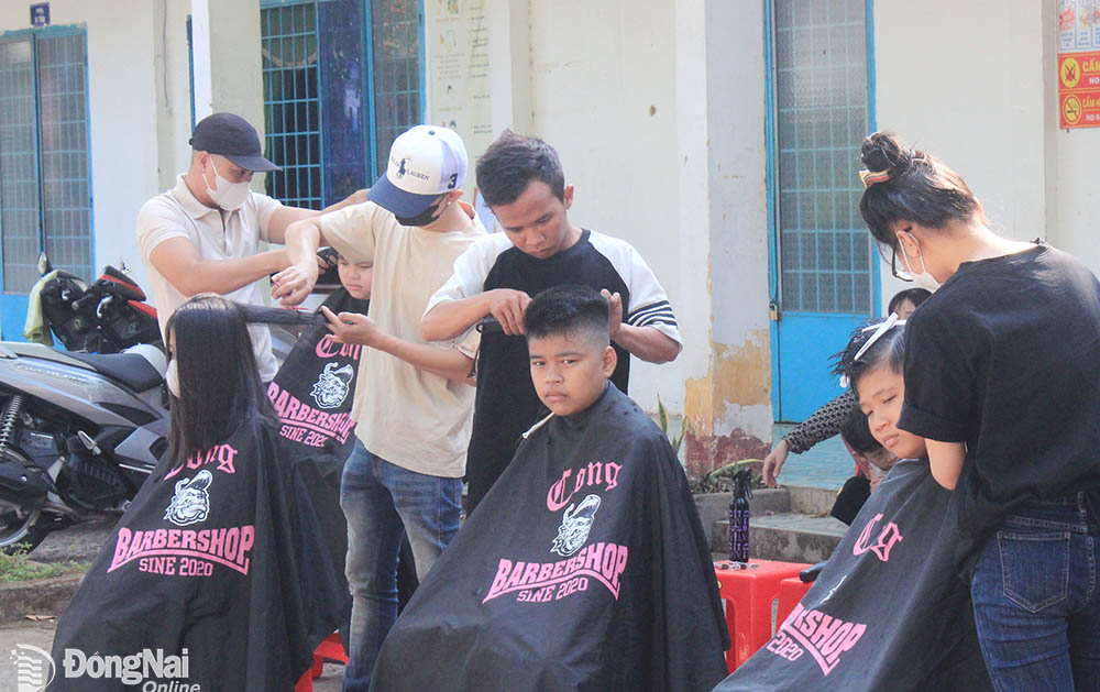 Thành viên Câu lạc bộ Tóc thanh niên huyện Trảng Bom tổ chức cắt tóc miễn phí cho người dân, học sinh tại xã Sông Trầu (huyện Trảng Bom). Ảnh: Nga Sơn