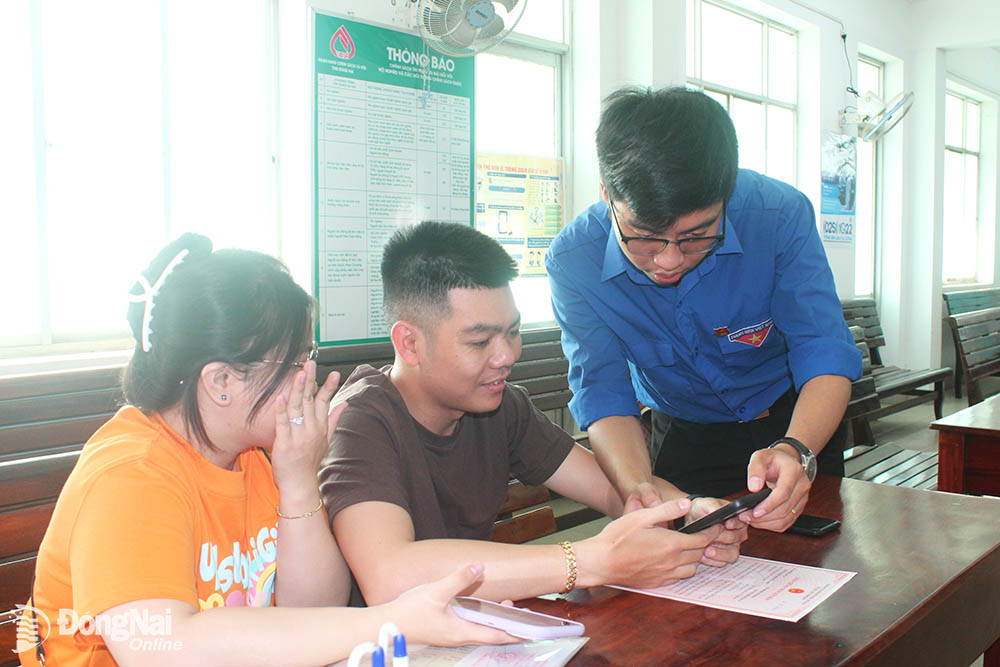 Đoàn viên, thanh niên phường Tân Biên (thành phố Biên Hòa) hỗ trợ người dân cài đặt và sử dụng tài khoản định danh điện tử. 