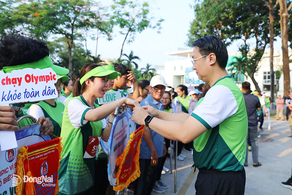Chủ tịch UBND thành phố Biên Hòa Đỗ Khôi Nguyên tặng cờ lưu niệm cho các đơn vị tham dự lễ phát động. Ảnh: Huy Anh