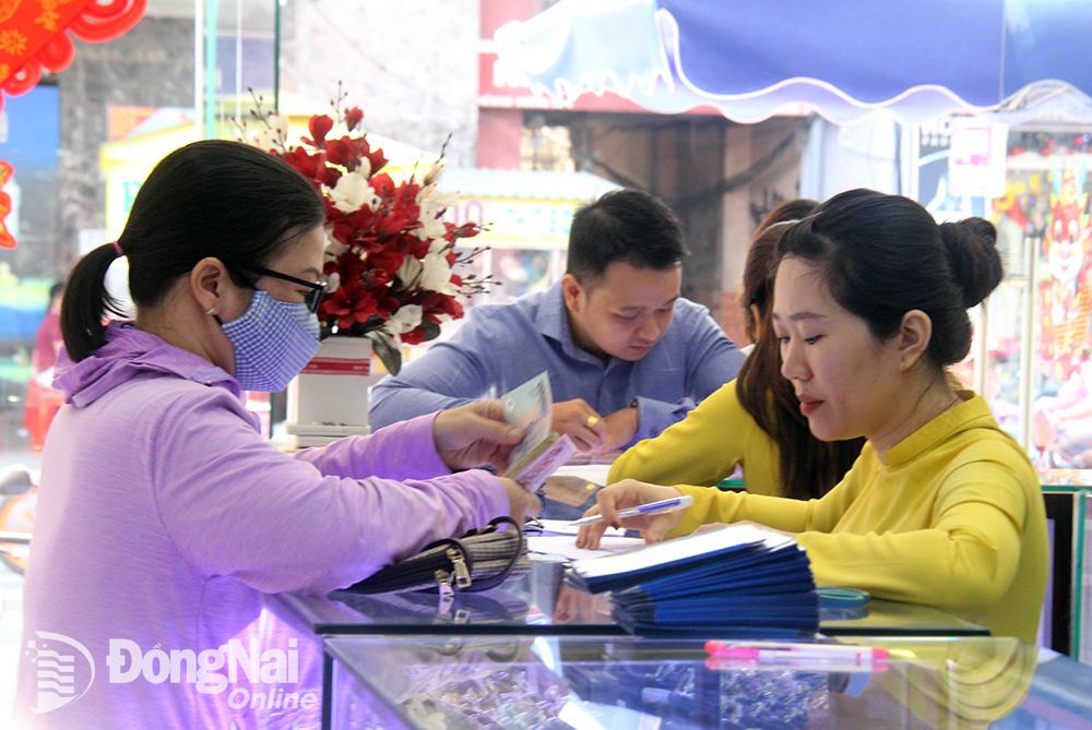 Người dân tham khảo giá các loại vàng miếng SJC tại một trung tâm kim hoàn ở TP.Biên Hòa. (Ảnh: Hải Hà)