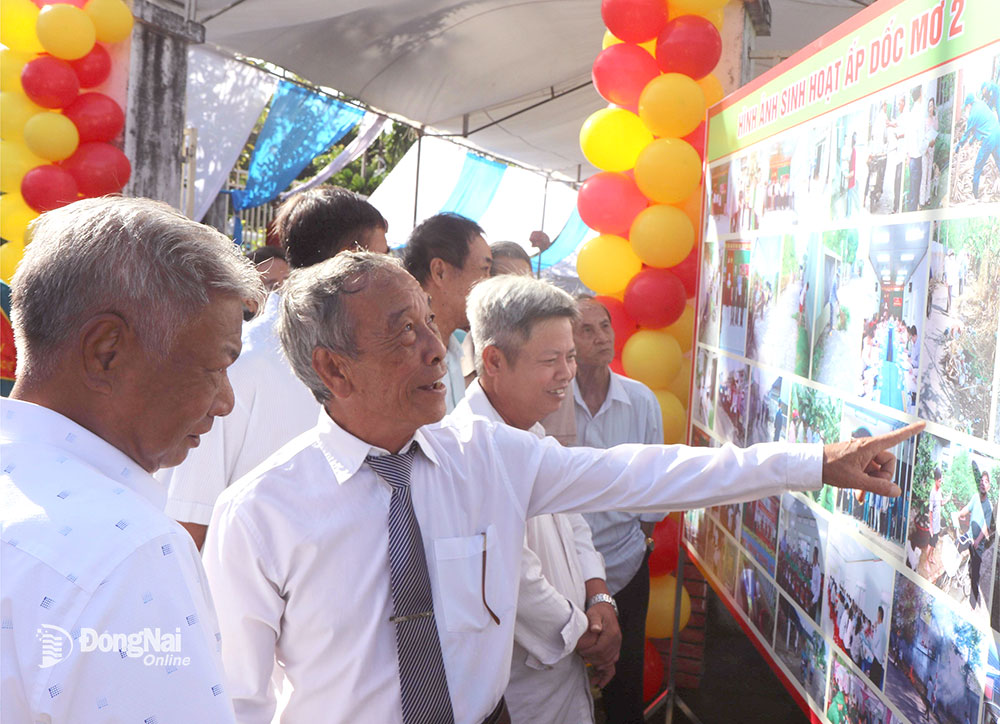 Người cao tuổi ở ấp Dốc Mơ 2 (xã Gia Tân 1, huyện Thống Nhất) xem hình ảnh về những hoạt động trong năm của hội người cao tuổi, câu lạc bộ liên thế hệ tự giúp nhau. Ảnh: S.Thao