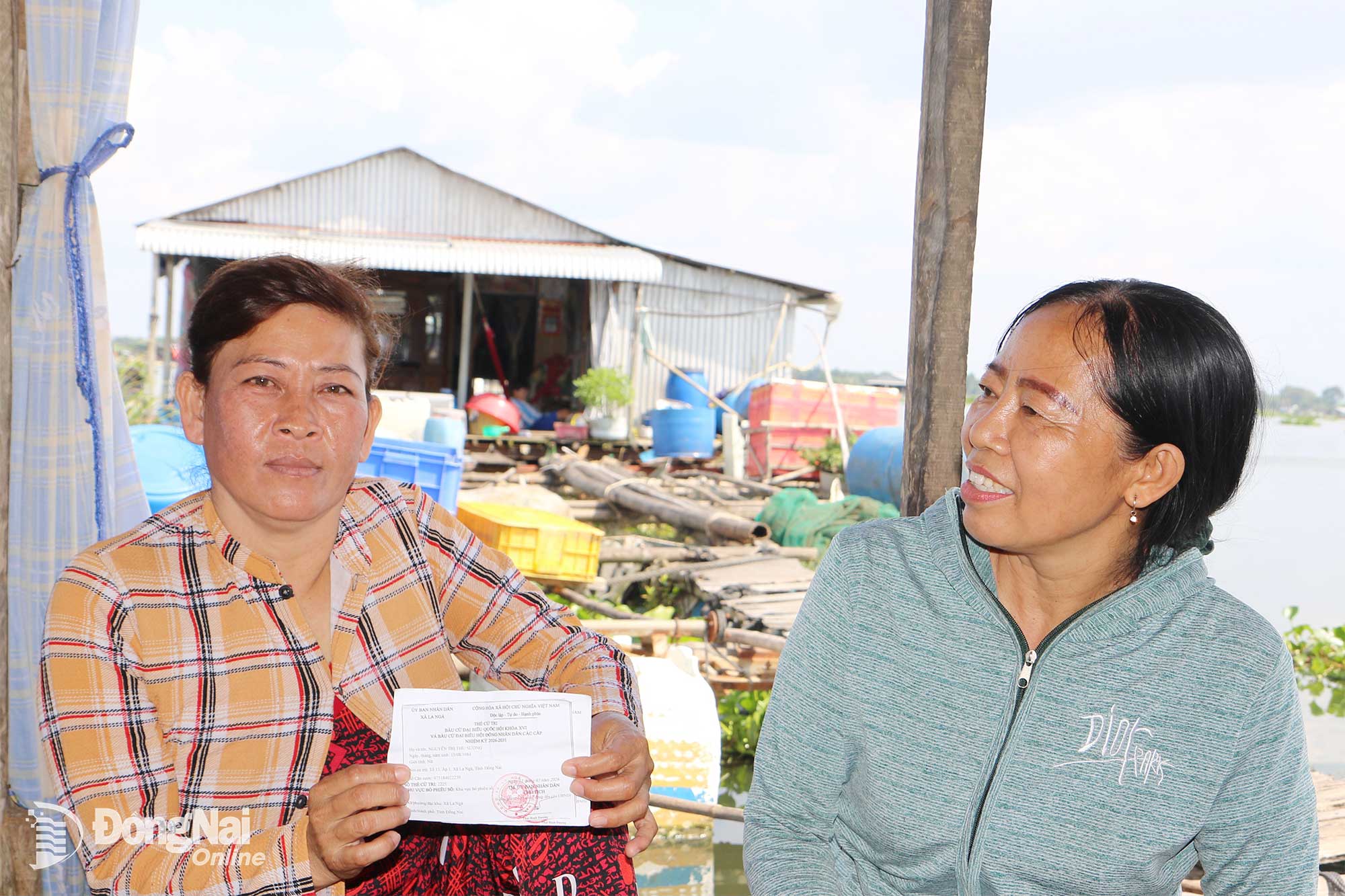 Nguyen Thi Thu Suong (living in the floating village in hamlet 1, La Nga commune) shows her voter card and those of other family members before voting for deputies to the 16th NA and People’s Councils at all levels for the 2026–2031 term like other Vietnamese citizens on March 15. Photo: Van Truyen