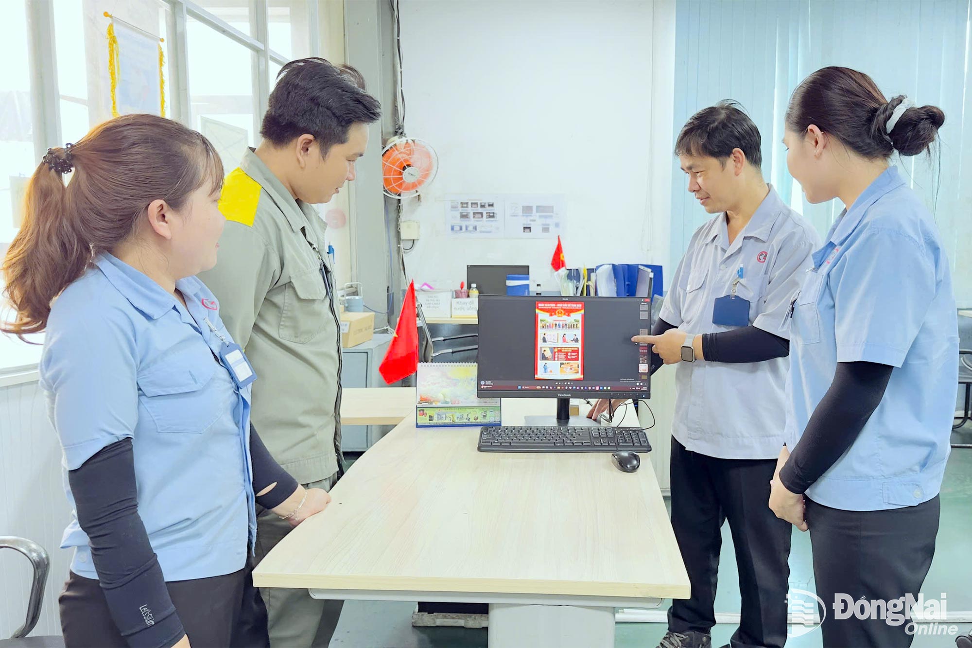 Workers of Global Powersports Manufacturing Incorporation follow election-related information on a computer screen.

