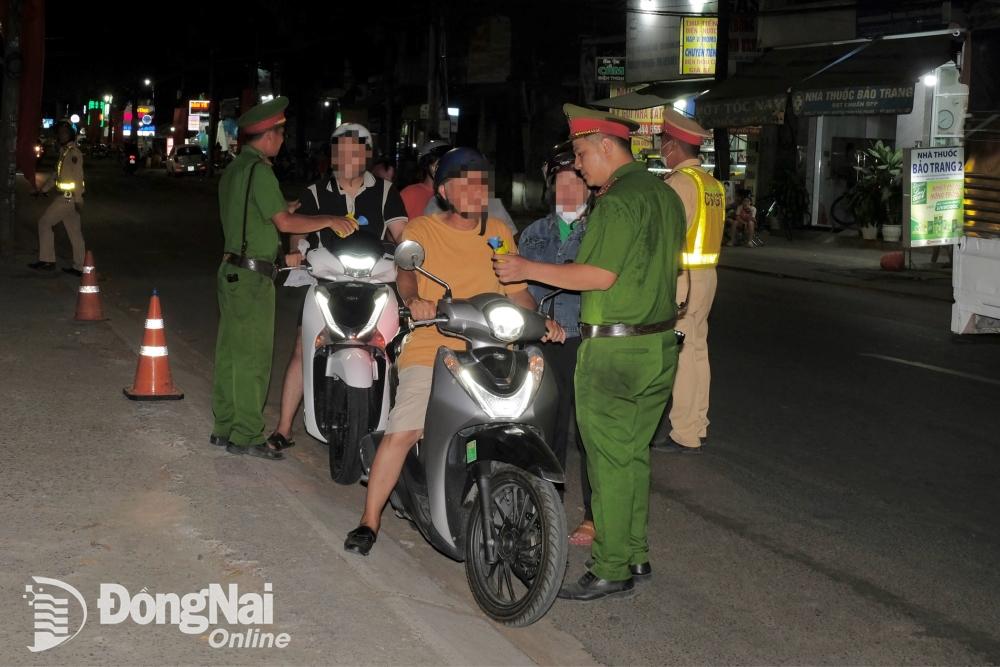 Lực lượng Cảnh sát giao thông kiểm tra nồng độ cồn người lái xe máy trên đường Trần Quốc Toàn (phường An Bình, thành phố Biên Hòa). Ảnh: Đăng Tùng