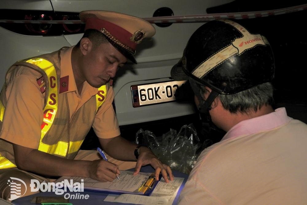 Lực lượng Cảnh sát giao thông lập biên bản một người đàn ông vi phạm nồng độ cồn tại phường An Bình (thành phố Biên Hòa) vào tối 28-4. Ảnh: Đăng Tùng